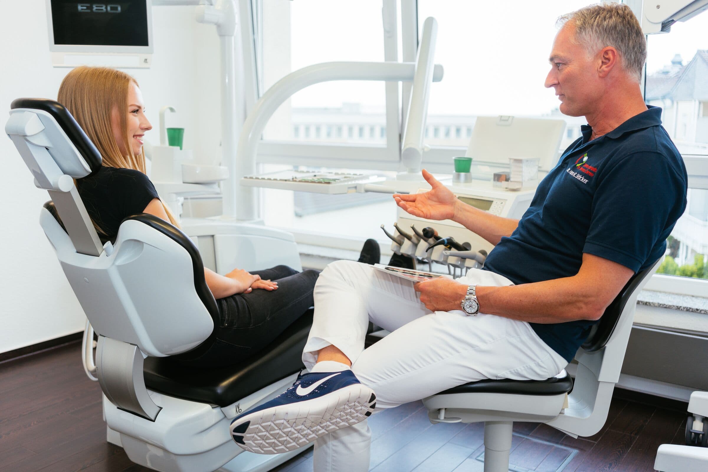 Dr. Stöcker bespricht mit einer Patientin im Behandlungsstuhl die Behandlung